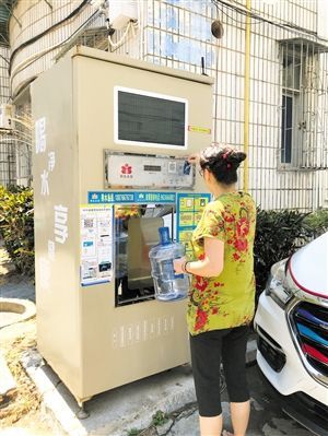 5月24日，瓊山區(qū)上丹花苑小區(qū)居民陳女士在使用共享凈水機取水。 本報記者 陳歆卓 攝